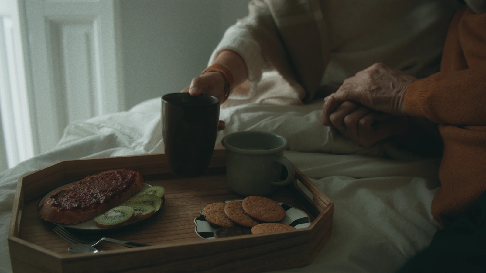 Hands, a glass and a plate on a table